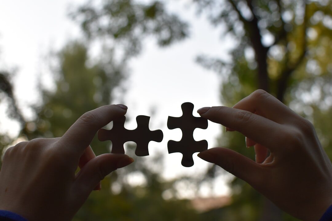 Hands assembling puzzle pieces together symbolizing collaboration